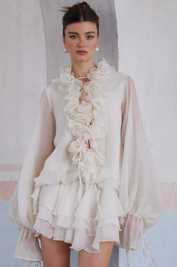 Elara – Gestuftes Minikleid mit Blumenapplikation in Neutraltönen