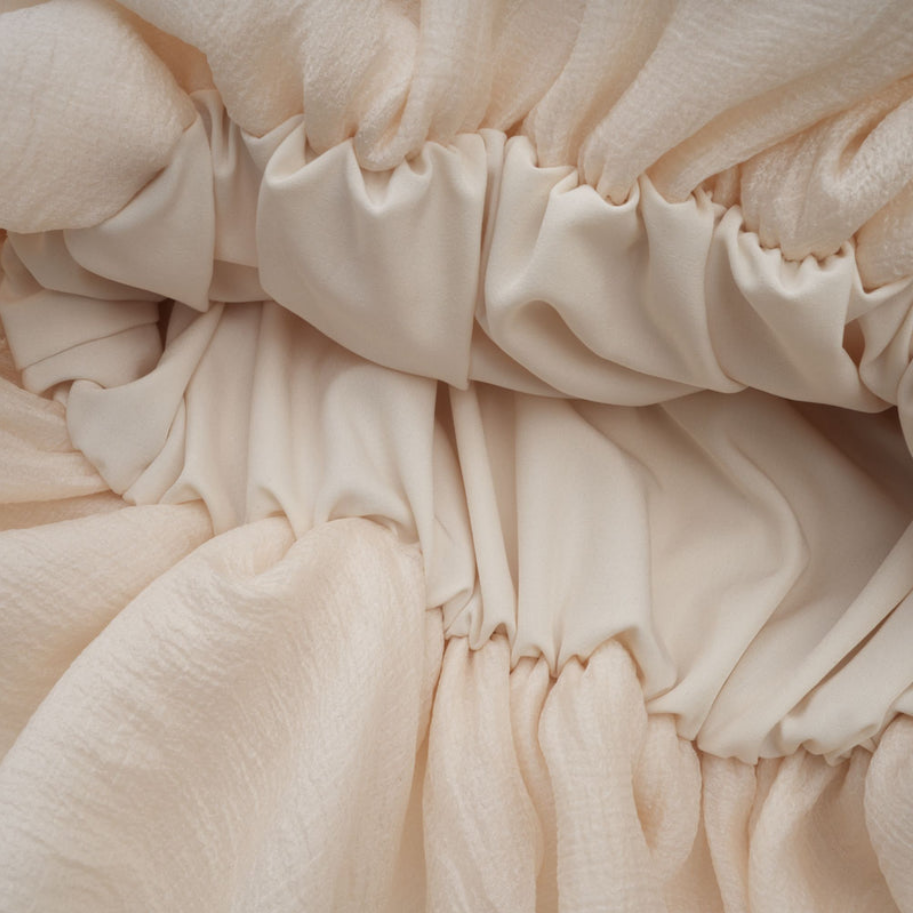 Elara – Gestuftes Minikleid mit Blumenapplikation in Neutraltönen